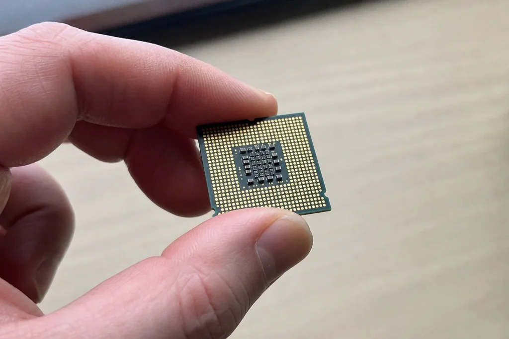 En hand håller varsamt ett litet mikrochip nära kameran, mot en suddig bakgrund, kopplat till EU:s satsning på AI-gigafabr...