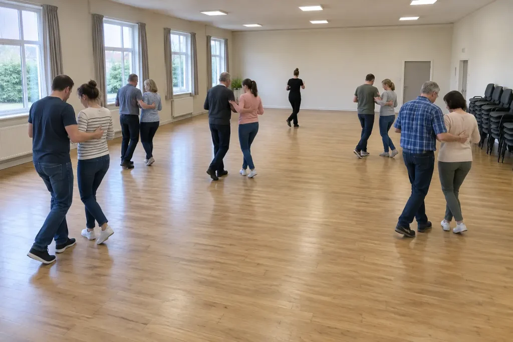 Nybörjare dansar i par under en lektion i bugg för nybörjare i en ljus samlingslokal